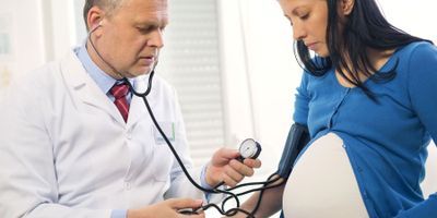 Pregnant woman at doctor's office having pressure measured 