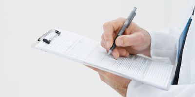 hands writing on a clipboard