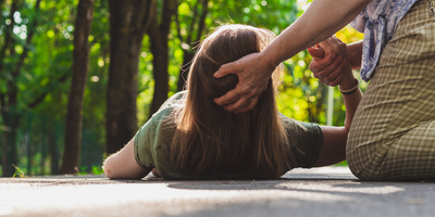 young woman being helped up after epileptic seizure