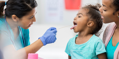 doctor examining young girl's throat