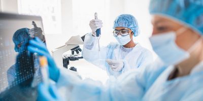 Clinical laboratory scientists wearing PPE and processing sars-cov-2 tests in the lab