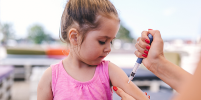 Photo of a young girl receiving an injection of teplizumab in her upper arm