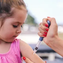 Photo of a young girl receiving an injection of teplizumab in her upper arm