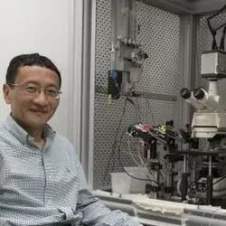 Photo of J. Julius Zhu, PhD, sitting at the new biosensor microscope at his lab at the University of Virginia Health System.
