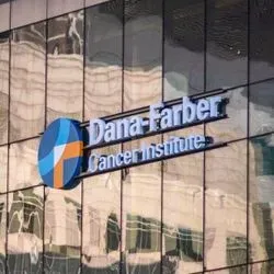 Photograph of the outside building of the Dana-Farber Cancer Institute. A sign with the institutes name is mounted in the front of the building.
