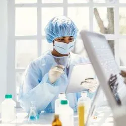 Photo of laboratory professionals wearing PPE in a science lab near a window