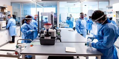 Lab professionals wearing PPE work in Northeastern's Life Science Testing Center