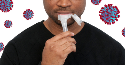 Photo of a Black man giving a COVID-19 saliva sample 