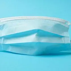Photo of a surgical mask against a blue background