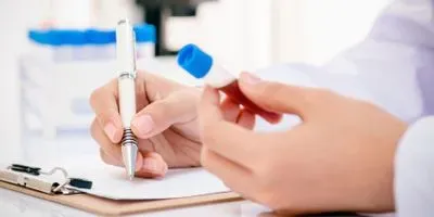 Researcher holding vial of blood for testing