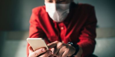 Person on their phone wearing a mask