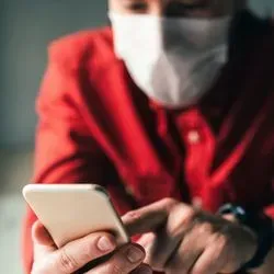 Person on their phone wearing a mask
