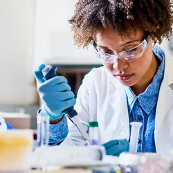 Photograph of lab personnel pipetting liquid using best practices for minimizing error and improving data quality 