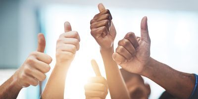 Photo of many people holding up their thumbs in approval