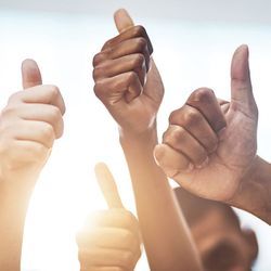 Photo of many people holding up their thumbs in approval