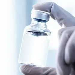 Photo of a lab professional holding up a vial of vaccine stored at ultra-low temperatures