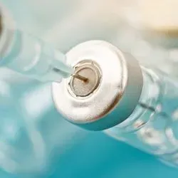 Needle drawing out a vaccine from a bottle