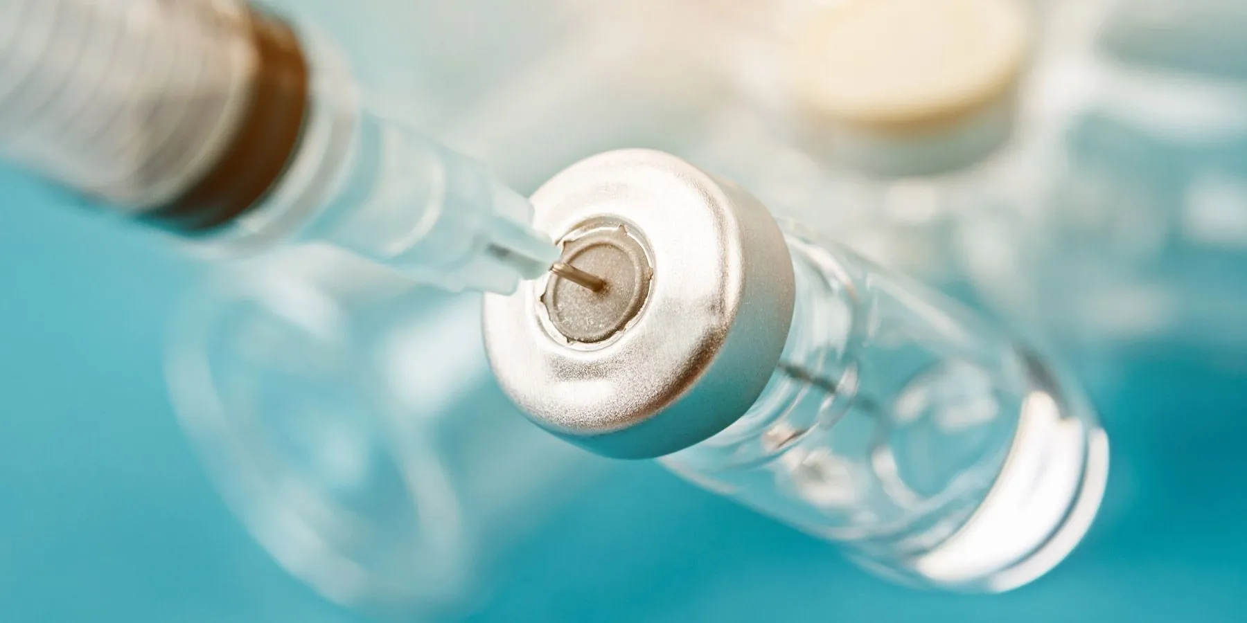 Needle drawing out a vaccine from a bottle