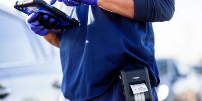 Photo of a clinical laboratory professional using a Brother Mobile point-of-care labeler for coronavirus sample