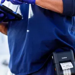Photo of a clinical laboratory professional using a Brother Mobile point-of-care labeler for coronavirus sample