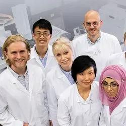 Photo of a group of clinical rotation students wearing lab coats in the lab