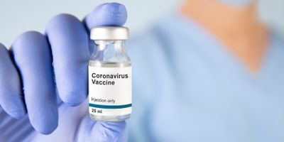 Medical professional holding a vial of COVID-19 vaccine