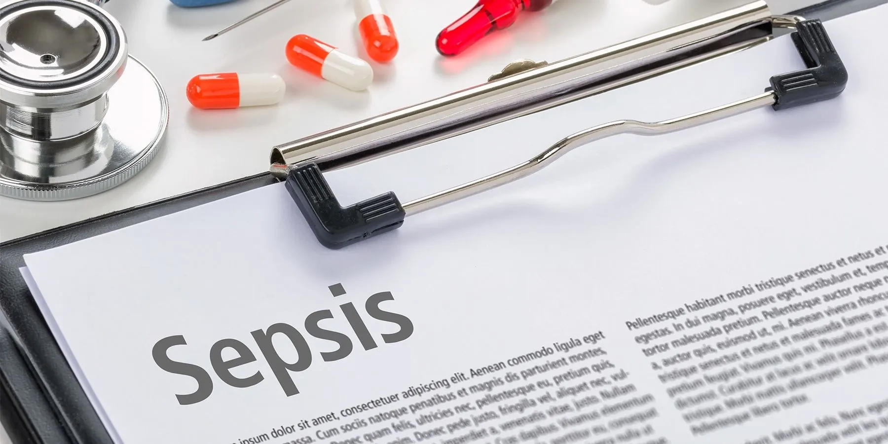 A clip board with an article about sepsis on it