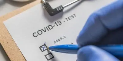 Medical professional checking off the positive box for a COVID-19 test