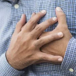 Man grasping chest in pain