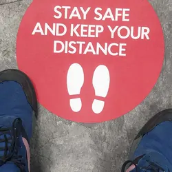 Person looking at a sign for social distancing