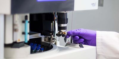 Photo of a clinical lab professional infecting a sample into a mass cytometer
