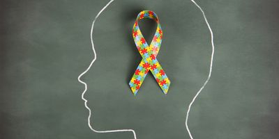 A chalk outline of a child with the autism ribbon inside