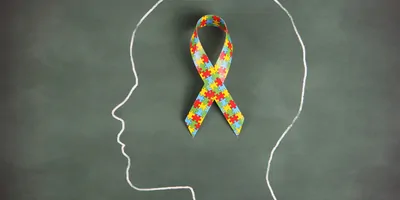 A chalk outline of a child with the autism ribbon inside