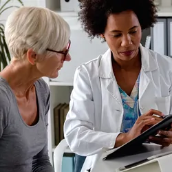 Female medical professional discussing treatment options with older female patient