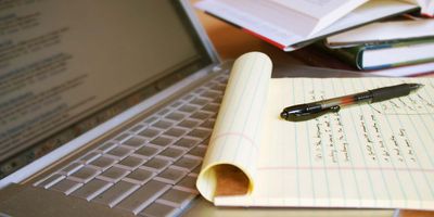 A note pad resting on a laptop