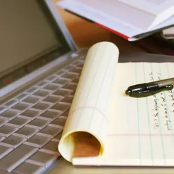 A note pad resting on a laptop