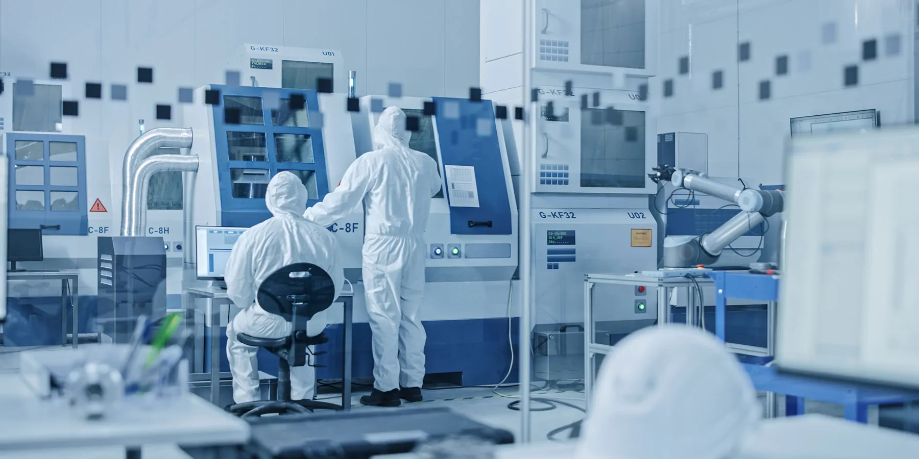 Photo of two clinical lab workers wearing PPE in a cell and gene therapy manufacturing facility