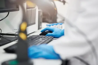 Image of Gloved Hands Typing on a Keyboard