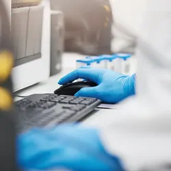 Image of Gloved Hands Typing on a Keyboard