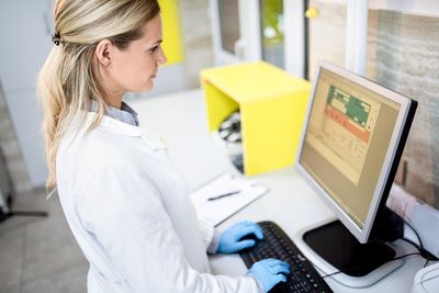 High Angle View of Young Female Doctor Using Computer in Laboratory