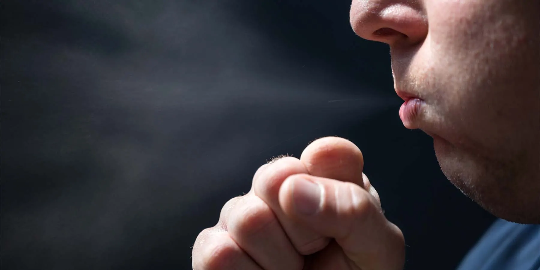 Man Coughing into his hand