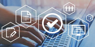 Illustration of a box with a checkmark inside superimposed over a photo of a person typing at a laptop