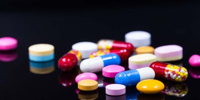 Photo of an array of novel psychoactive substances in pill form on a black background
