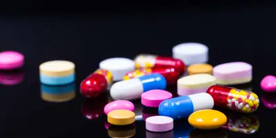 Photo of an array of novel psychoactive substances in pill form on a black background