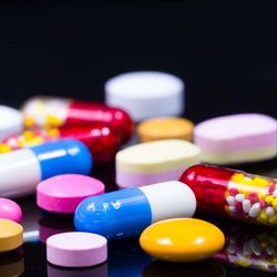 Photo of an array of novel psychoactive substances in pill form on a black background