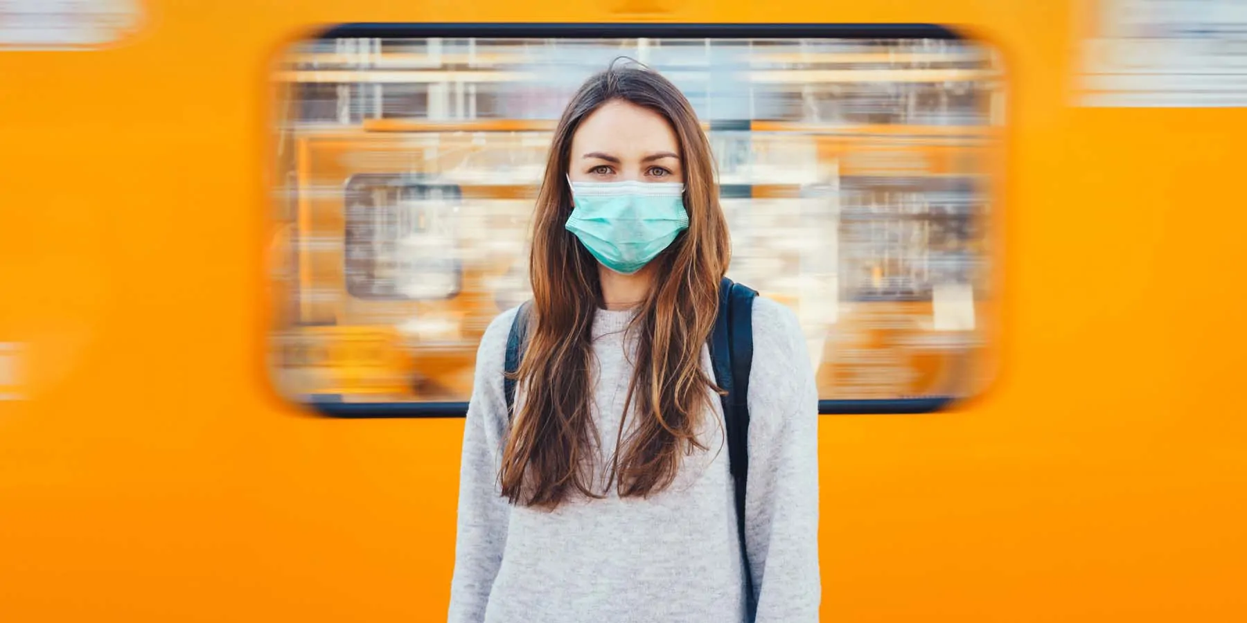 Women with Long COVID-19 May Need Targeted Rehabilitation Woman with a face mask on in front of a train looking at the camera