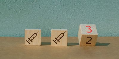 Wooden blocks with syringes on them and on block has the number 3 in red