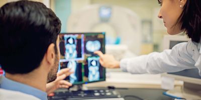 Researchers looking at a computer with MRI images on it