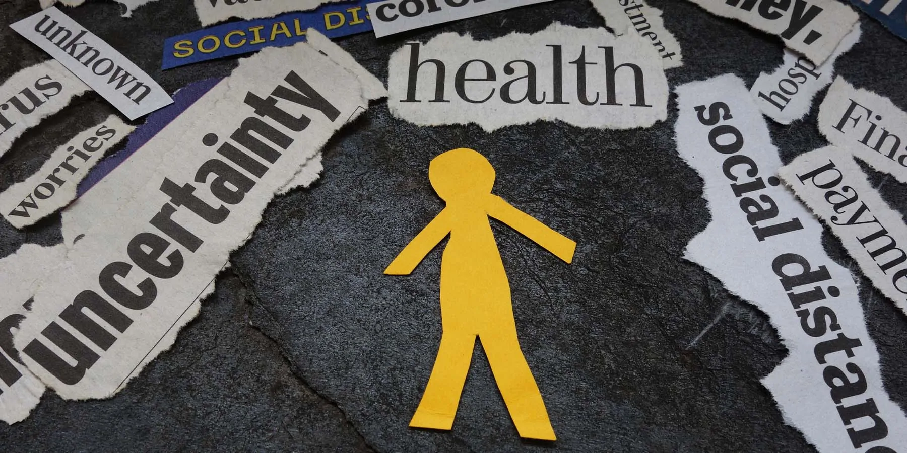 Yellow paper cutout of a human surrounded by newspaper headlines