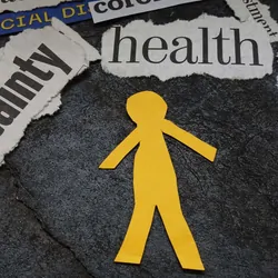 Yellow paper cutout of a human surrounded by newspaper headlines